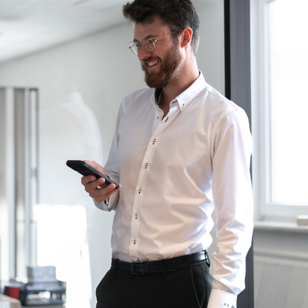Roland Bernert mit Handy im Büro